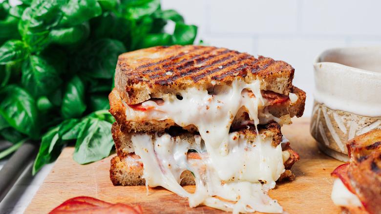 Two stacked pizza grilled cheese halves on cutting board