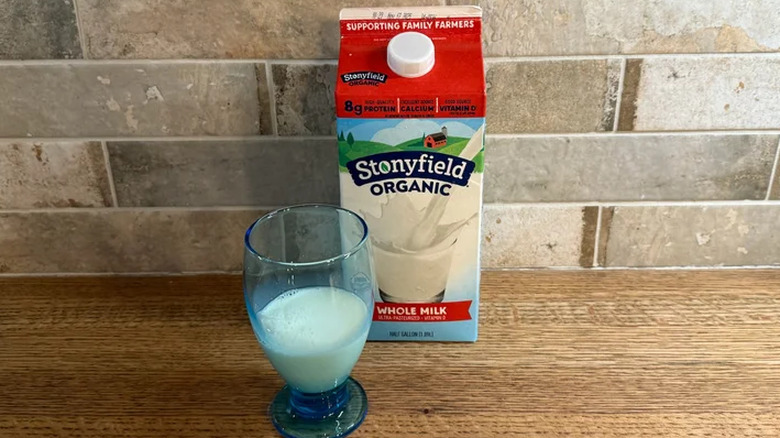 A carton of Stonyfield Organic milk next to a glass of milk