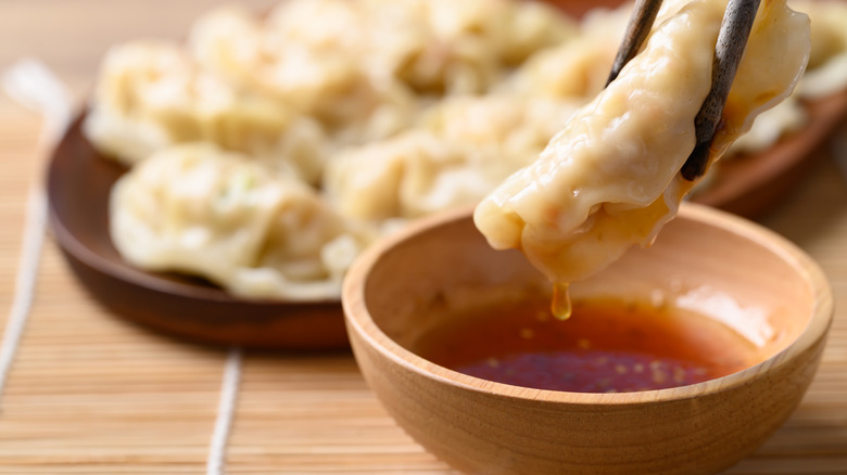 chicken dumplings being dipped in sauce
