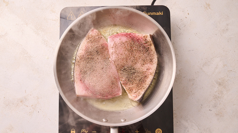 searing swordfish in a skillet