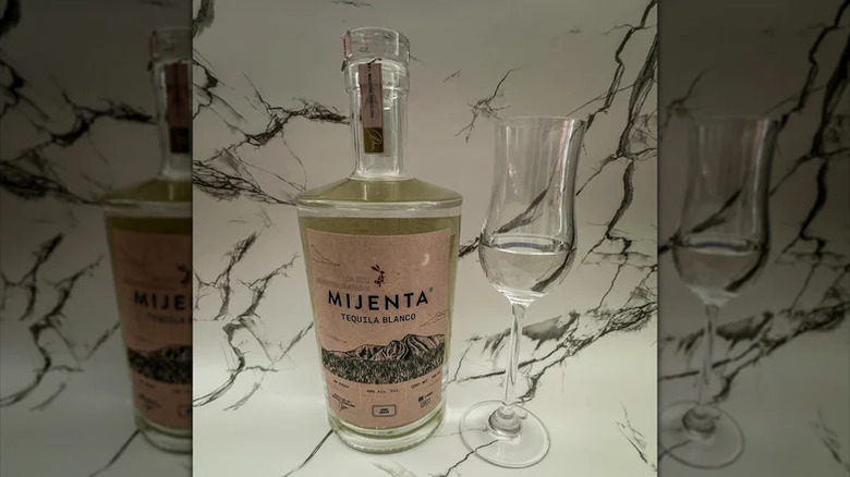 Mijenta tequila blanco bottle with tasting glass