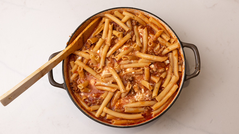 assembling ziti pasta dish
