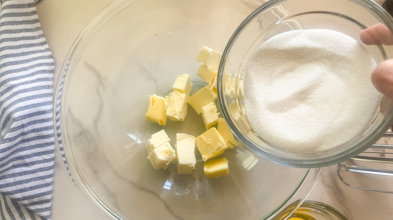 hand adding sugar to bowl
