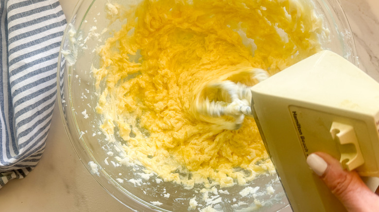 hand beating mixture in bowl