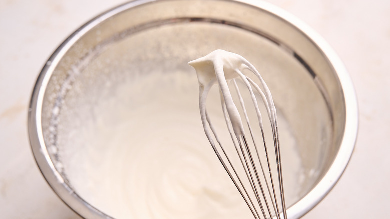whipped cream on the tip of a whisk