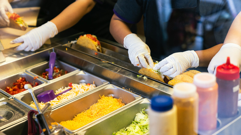 Employees making Mexican meals behind the counter