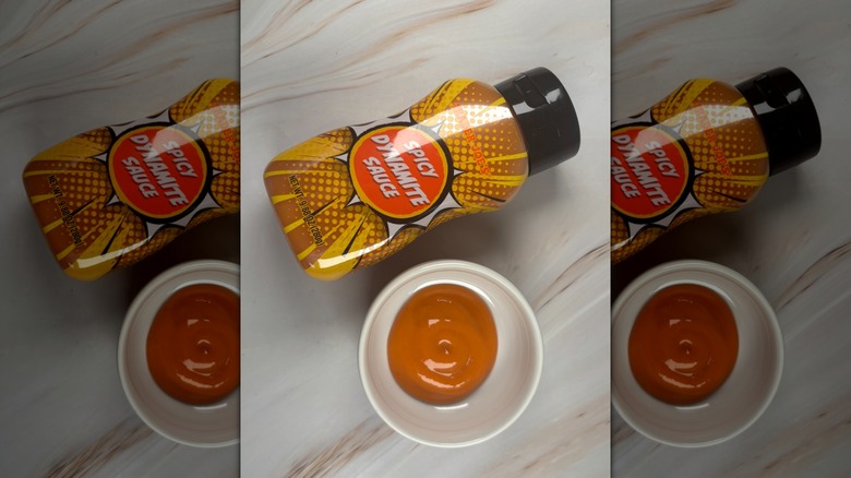 Trader Joe's Spicy Dynamite Sauce on a table next to a small white dish of the sauce