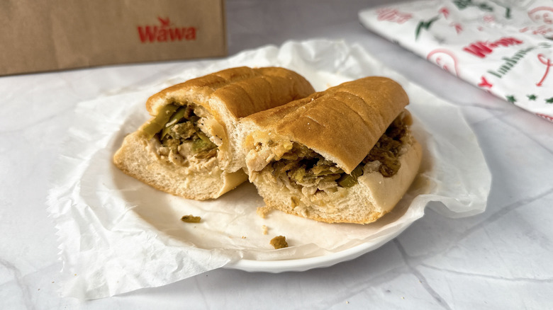 Wawa chipotle chicken cheesesteak sandwich cut in half on white plate