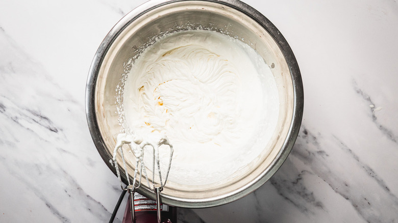 Whipped cream in bowl with mixer