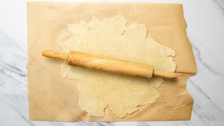 Rolling out pie dough on parchment paper