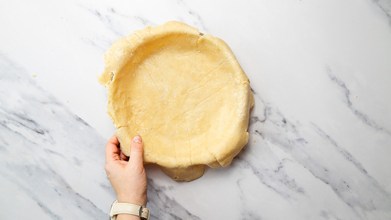 Shaping pie dough in pan