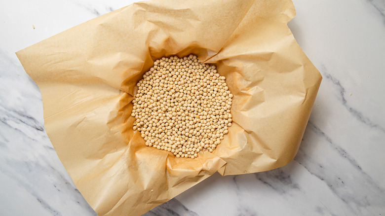 Crust with baking beans on parchment paper