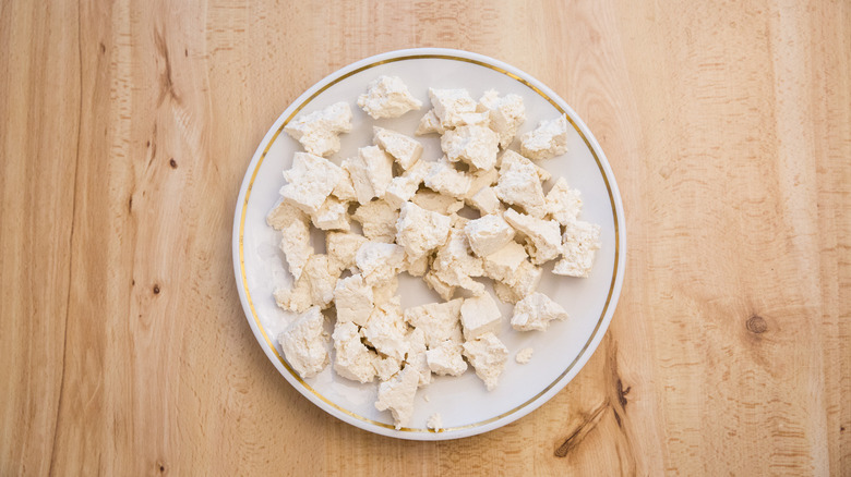 torn tofu on white plate