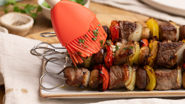 brushing kabobs with garlic butter