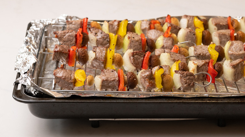 partially cooked kabobs on tray