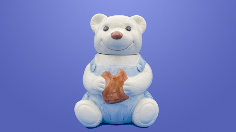 A glazed cookie jar in the shape of a teddy bear against a blue background