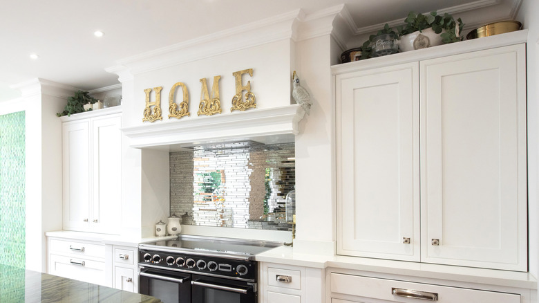 White kitchen interior with brass letters spelling 'home'