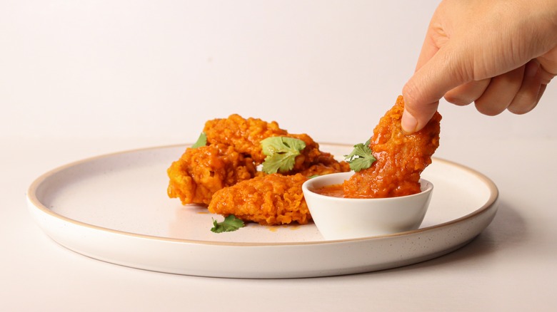 Person holding a boneless wing