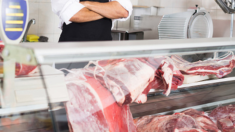 butcher looking over different meats