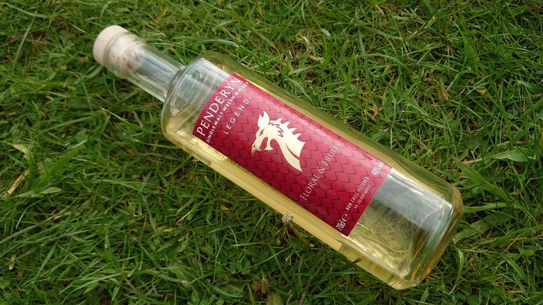 Bottle of Penderyn Legend laid diagonally on grass