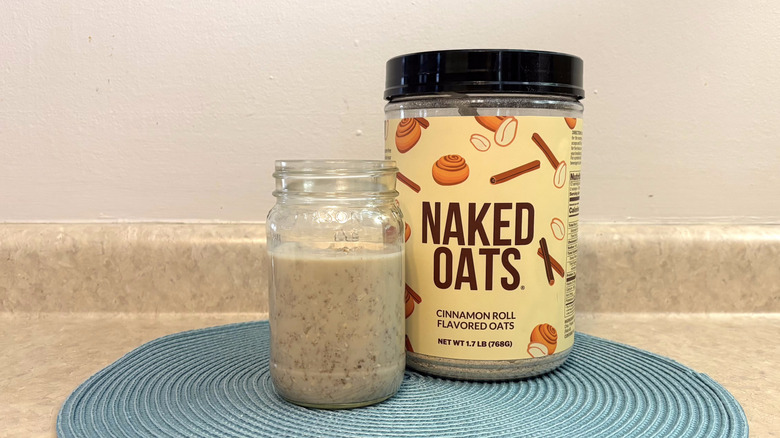 Naked cinnamon roll overnight oats mix in a mason jar on blue placemat, beige countertop