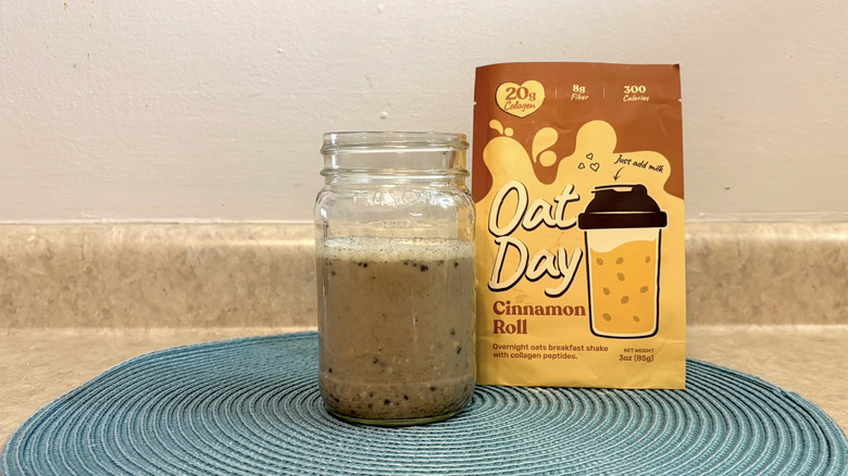 Oat Day cinnamon roll overnight oats mix in a mason jar on blue placemat, beige countertop