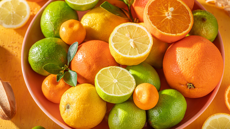 Mix of citrus fruit on yellow table.