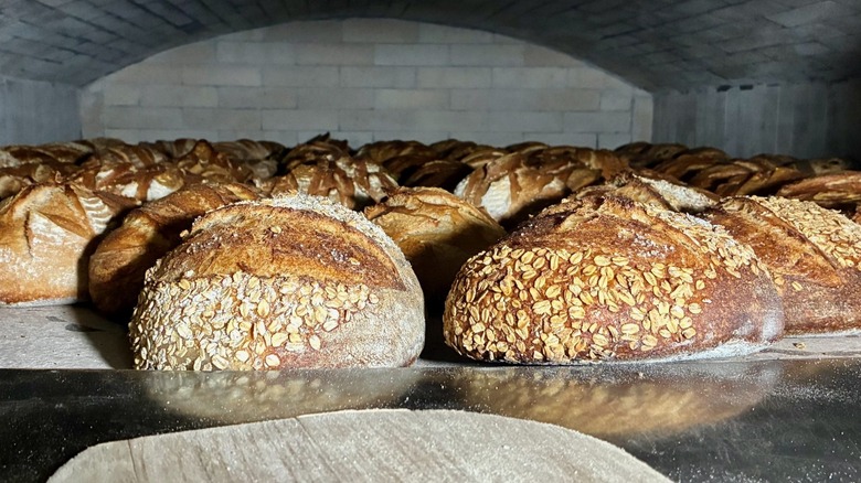 A long table stacked with fresh, crusty sourdough loaves at Wild Flour Bread