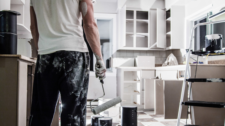 person painting kitchen cabinets