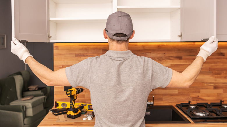 Person installing new kitchen cabinets