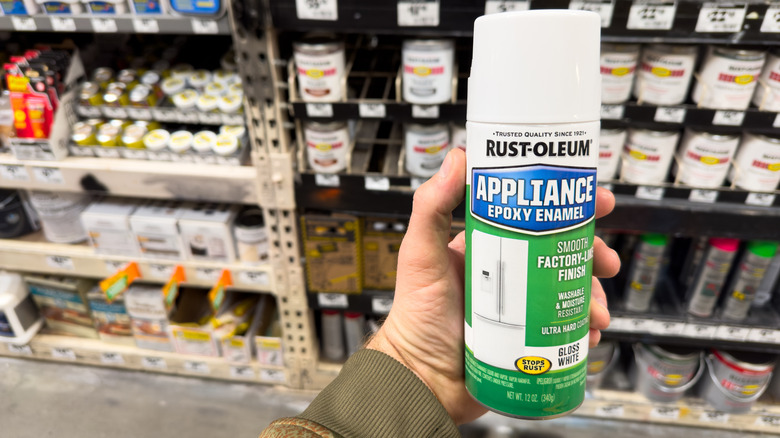 A man holding a spray can of Rust-Oleum appliance paint in a store