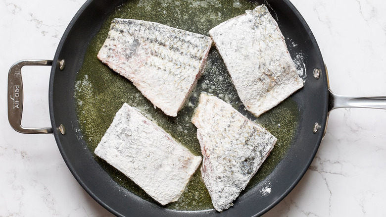 Rockfish fillets skin side-up in buttered pan