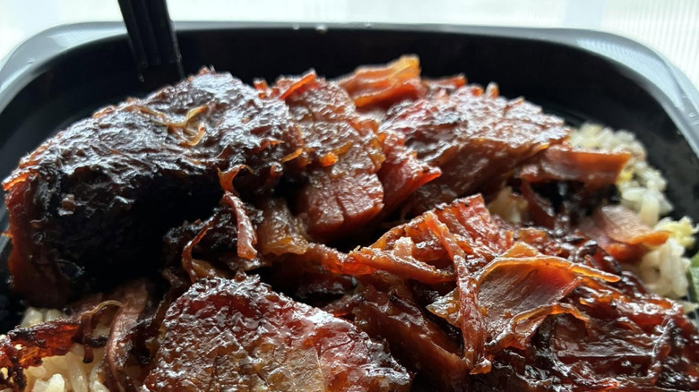 A bowl of Cantonese BBQ Beef Brisket in a bowl with rice and a fork.
