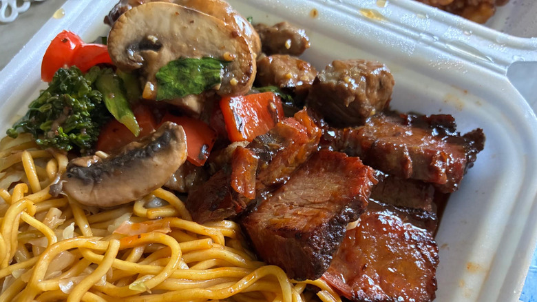 Panda Express' Cantonese Beef Brisket in a takeout container with noodles and vegetables.
