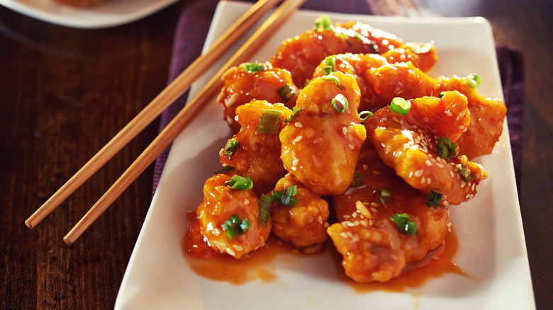 Plate of orange chicken with chopsticks
