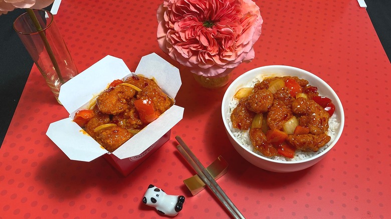 Takeout container and bowl of Panda Express Dynamite Sweet & Sour Chicken on table
