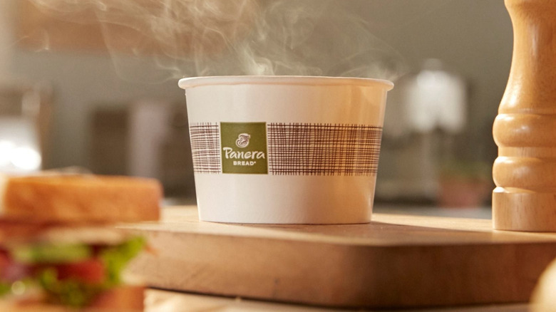 bowl of panera bread soup next to pepper and sandwich