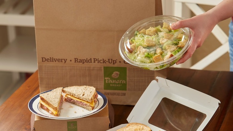Hand holding Panera take out