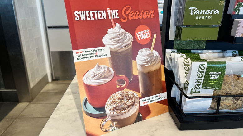 Seasonal drinks sign at Panera next to cookies and gift cards