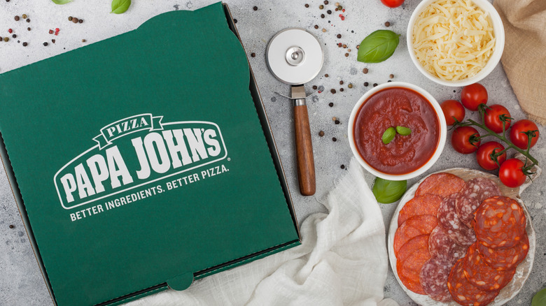 papa john's pizza box with sauces and roller