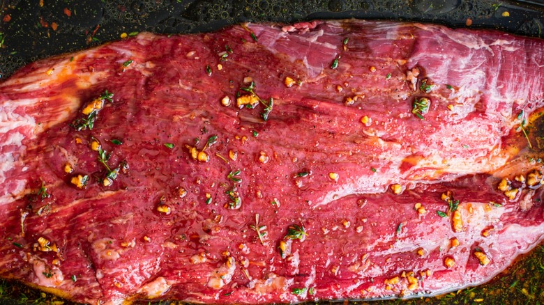 steak marinating in dish