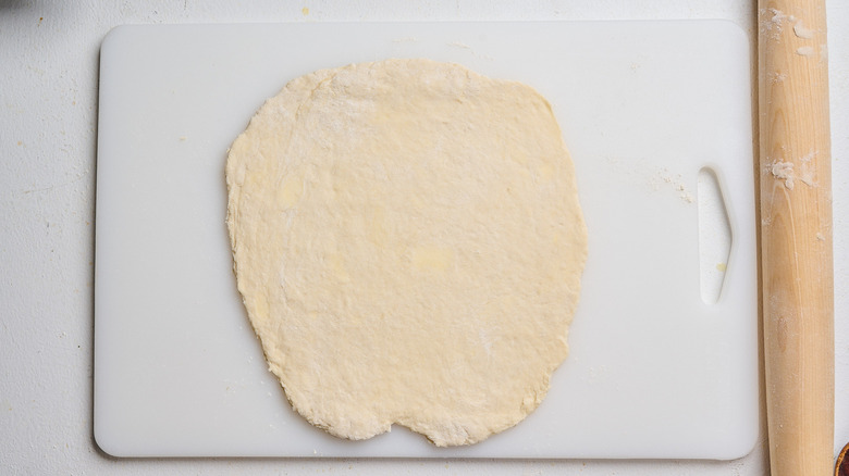 dough rolled flat on a cutting board