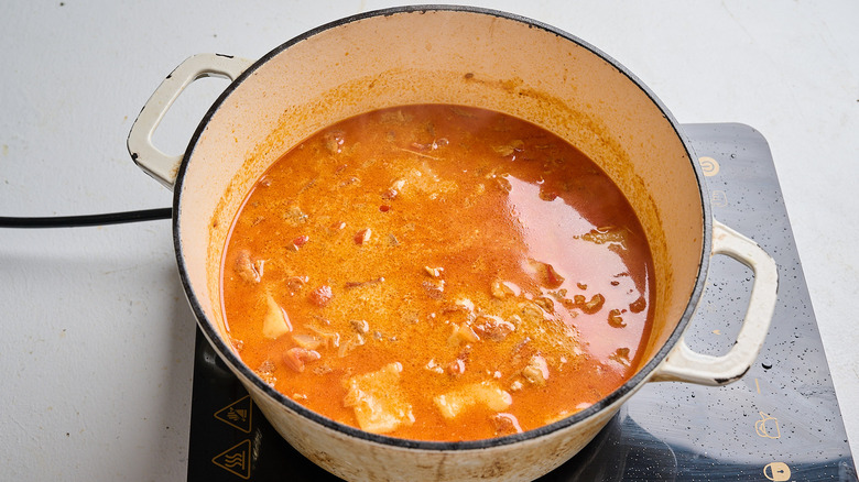 chicken and cream added to soup in pot
