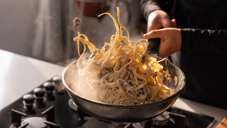 pasta being flipped in saucier