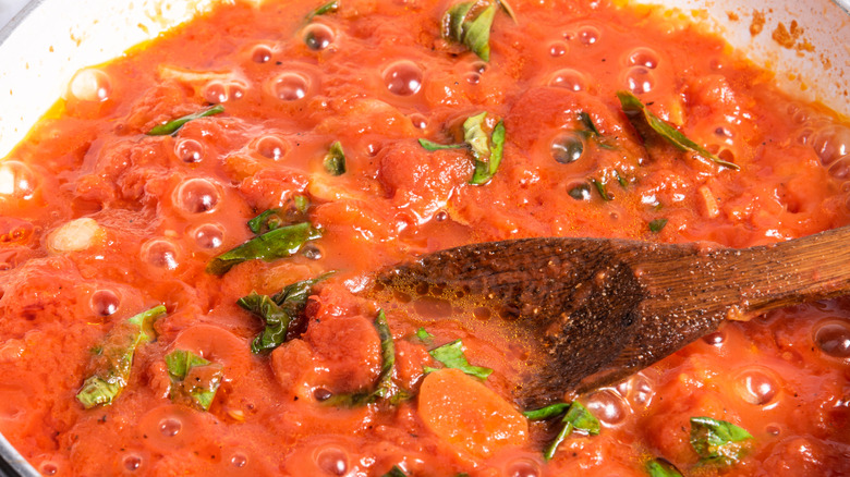 cooking marinara sauce with basil