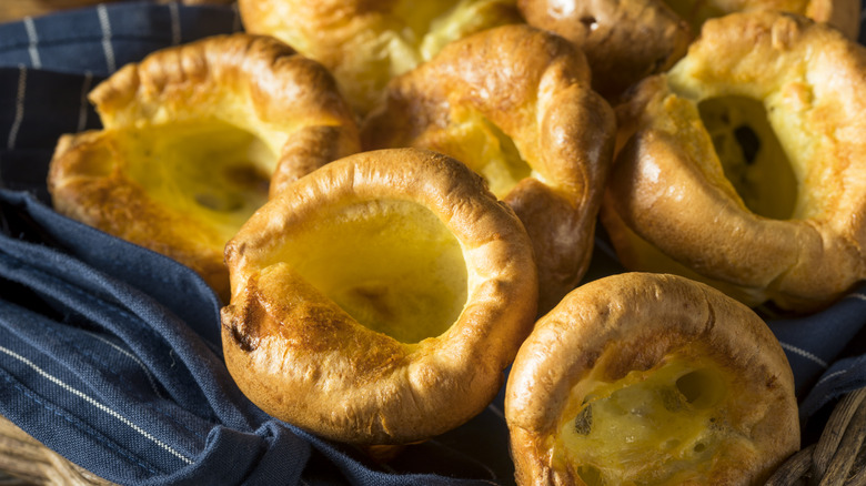 Fresh Yorkshire puddings on a blue striped dish towel