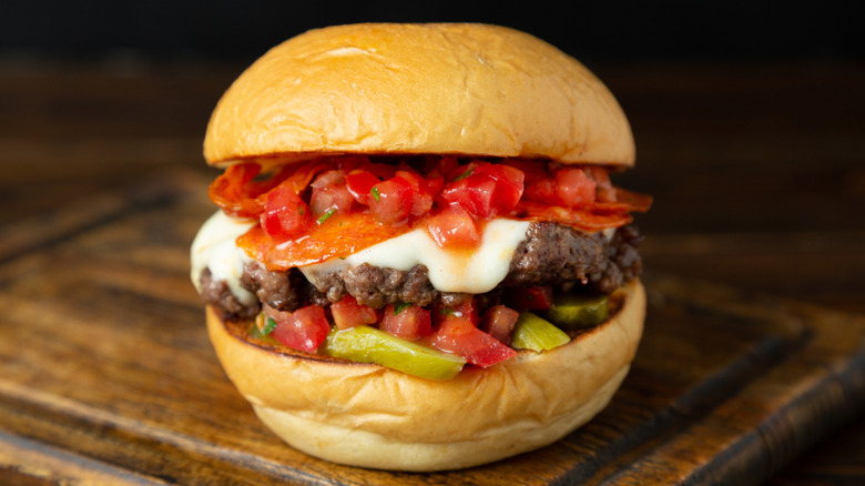 a person preparing burgers on a grill
