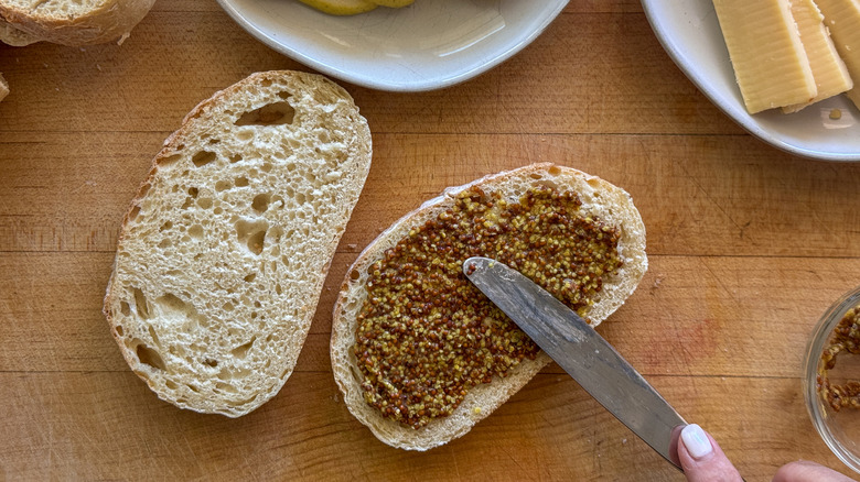 spreading mustard on bread