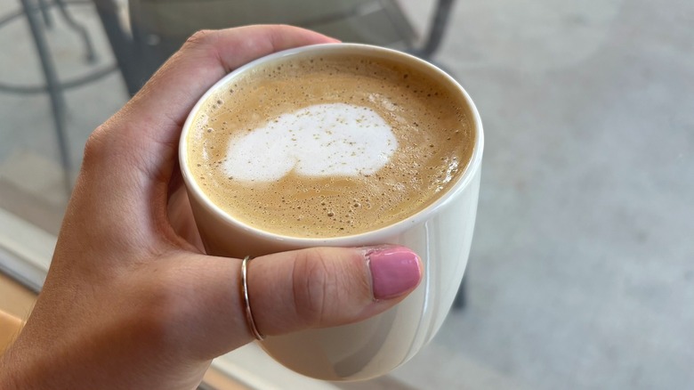 Mug of Starbucks Pecan Oatmilk Cortado in-hand