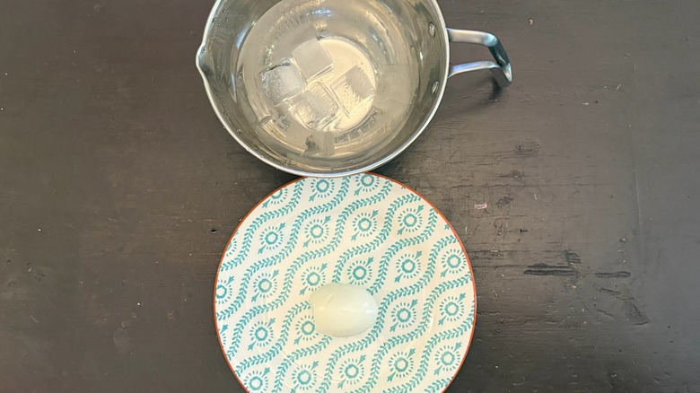 an bowl with ice and a peeled hard-boiled egg